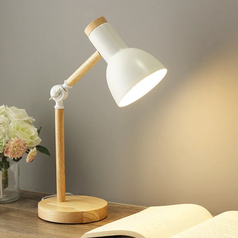 Weiße Schreibtischlampe mit Holzarm auf Nachttisch neben Buch und Blumen