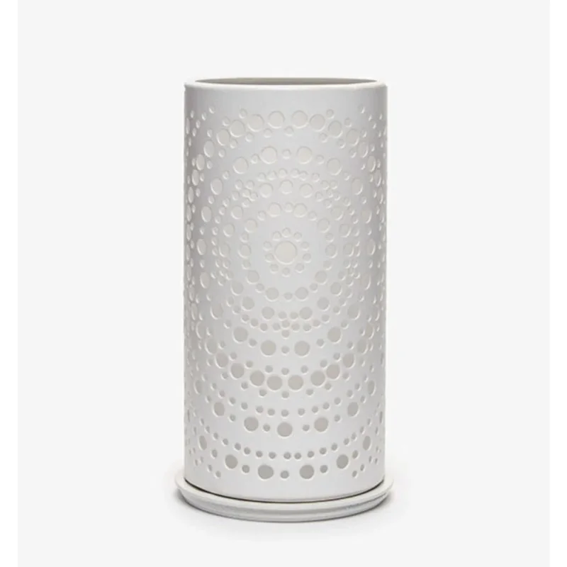 Eine weiße zylindrische Vase mit einem modernen perforierten konzentrischen Punktmuster, das an den eleganten Duni Kerzenhalter Billy Metall von Duni GmbH erinnert, steht vor einem schlichten weißen Hintergrund.
