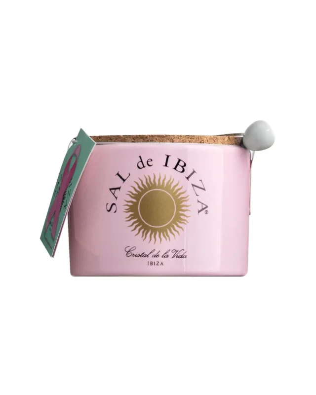 Das Sal de Ibiza 'Fleur de Sel La Vie en Rose' Meersalz mit Rosenblättern (140 g) wird in einem rosafarbenen Keramiktopf mit goldenem Sonnenlogo, Korkdeckel, grünem Anhänger und weißem Löffel geliefert - eine elegante Ergänzung für jeden Tisch.