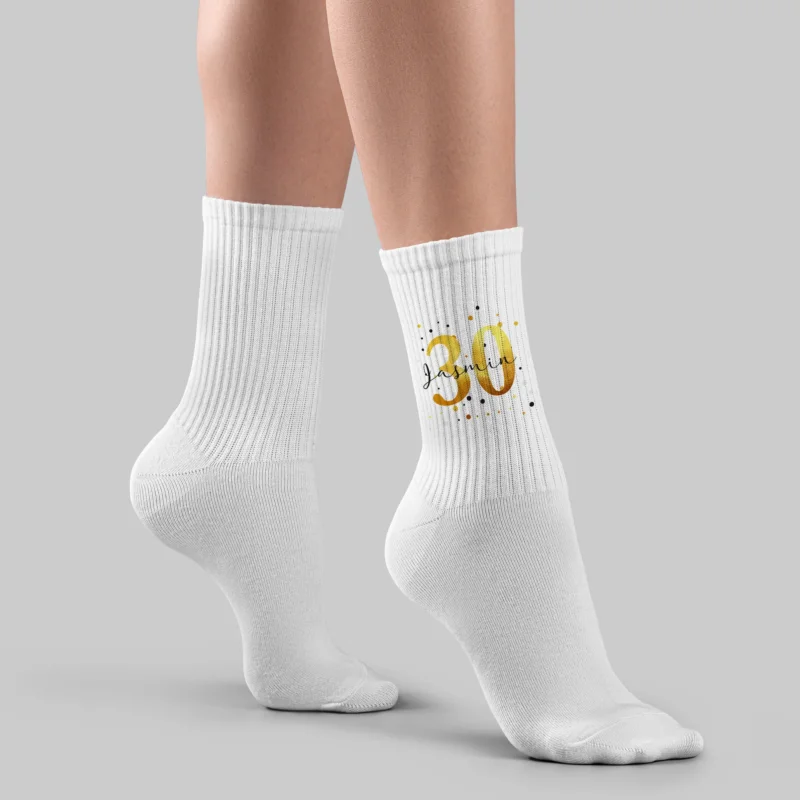 Weiße Sportsocken mit goldener 30 und Name Jasmin auf grauem Hintergrund, getragen